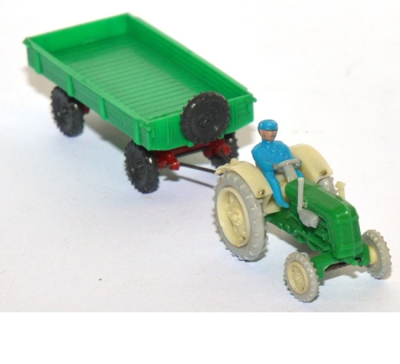 Traktor Famulus RS 32 mit Fahrer und landwirtschaftlichen Anhänger grün