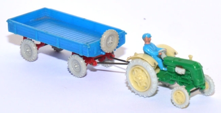 Traktor Famulus RS 32 mit Fahrer und Anhänger grün