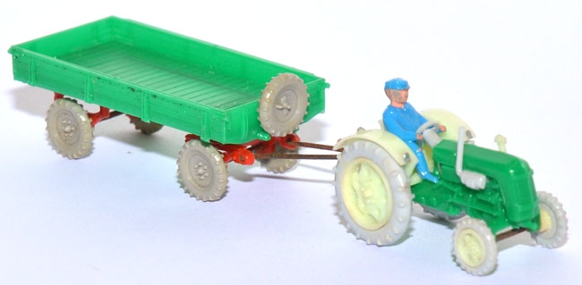 Traktor Famulus RS 32 mit Fahrer und Anhänger grün